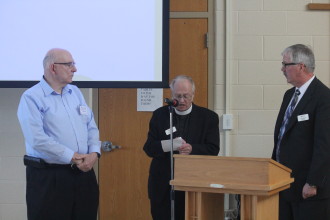 Michigan District president Chuck Bennett (right) and secretary Randy Larson (left) are installed by Michigan District pastoral advisor.